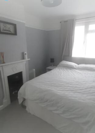 A well-lit and inviting double bedroom with a c...