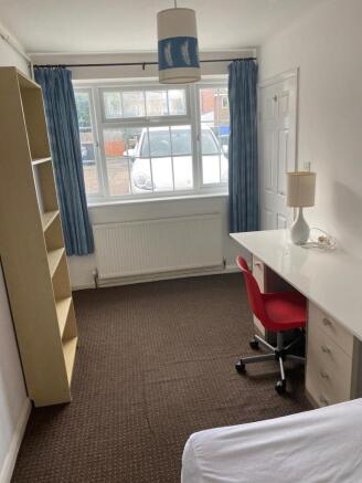 A bright and tidy double bedroom featuring larg...