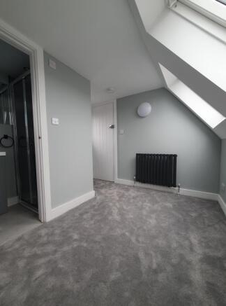 This inviting double bedroom features soft grey...