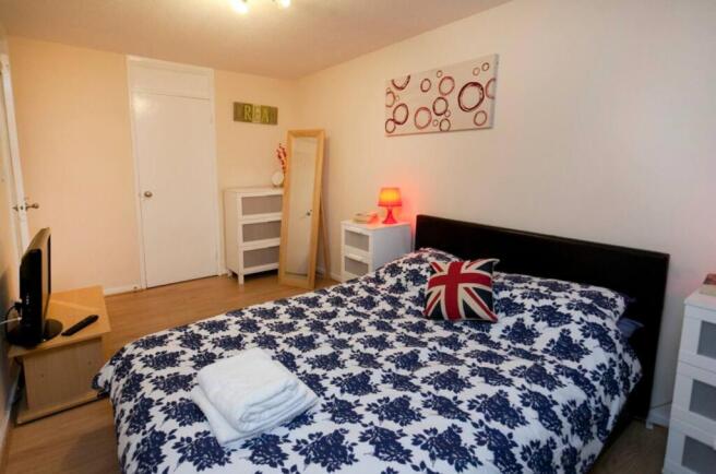 A bright and inviting double bedroom with styli...