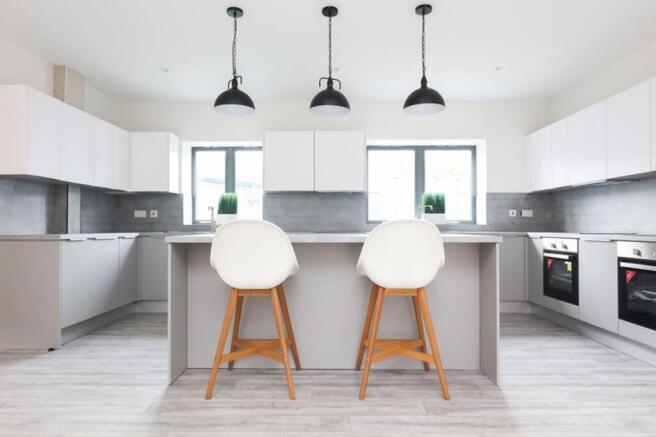 A spacious and modern kitchen featuring sleek c...