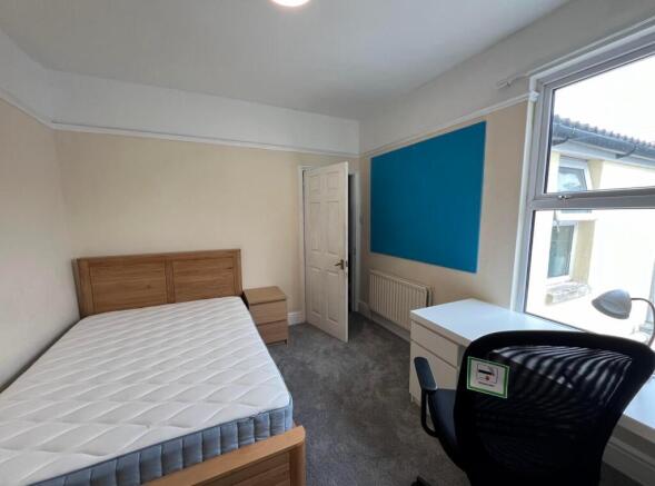 A spacious and well-lit double bedroom featurin...