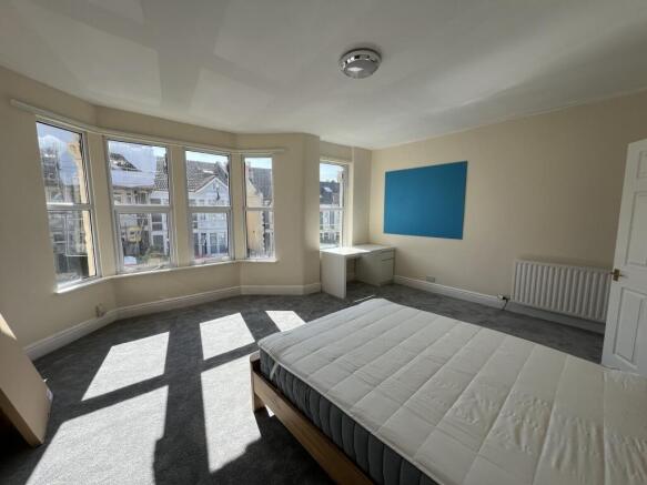 Bright and spacious master bedroom with a large...