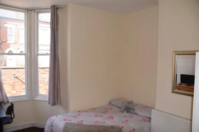 A bright and inviting double bedroom featuring ...