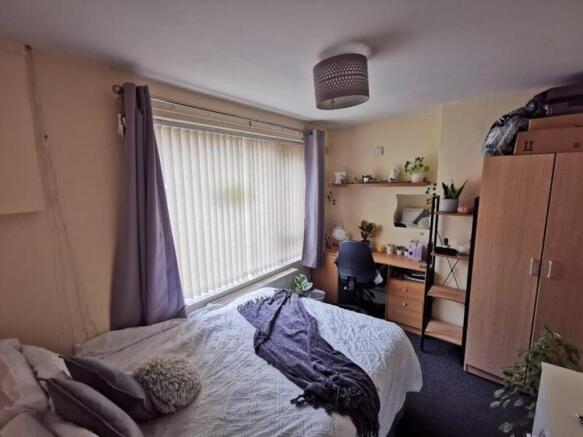 A bright and inviting double bedroom with a coz...