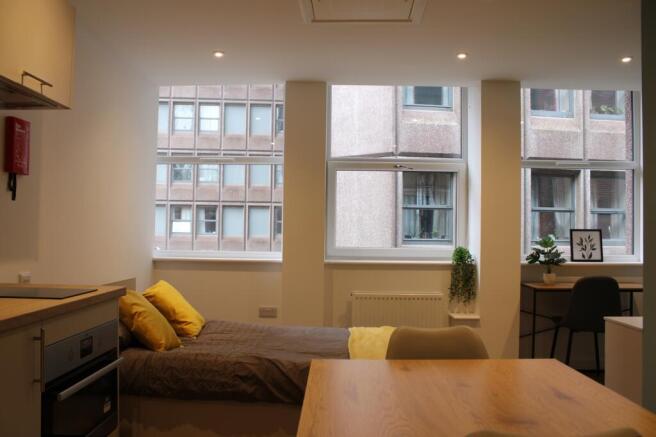A bright and modern kitchenette with ample natu...