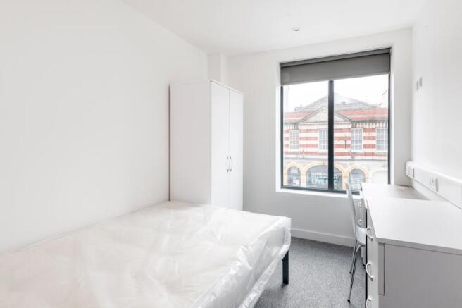 A bright and tidy double bedroom featuring larg...
