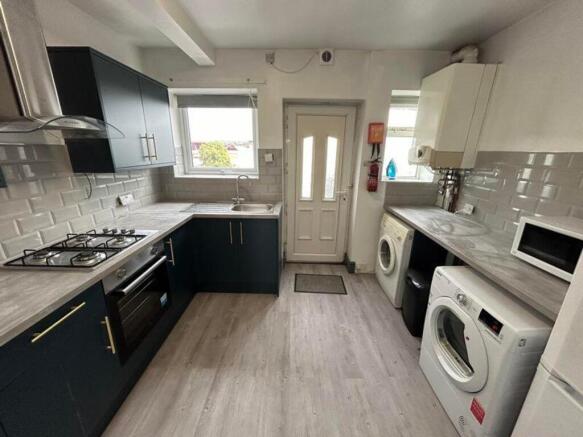 A modern and spacious kitchen featuring ample s...