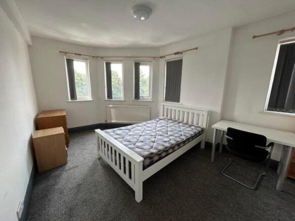 A spacious and well-lit double bedroom with mod...