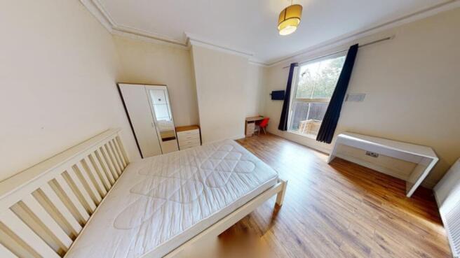 A spacious and bright double bedroom featuring ...