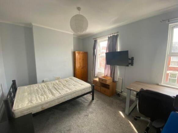 A spacious and well-lit double bedroom featurin...