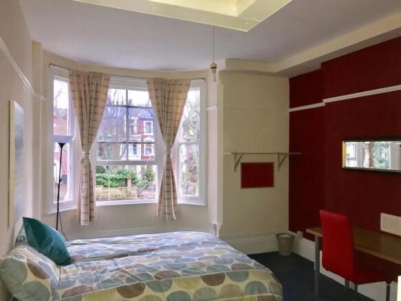 A bright and inviting double bedroom with large...