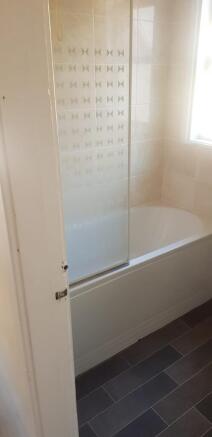 A clean and tidy bathroom featuring a bathtub a...