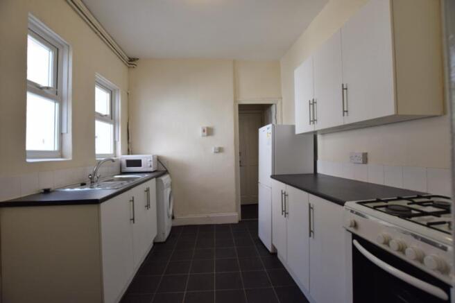 A spacious and tidy kitchenette with ample stor...