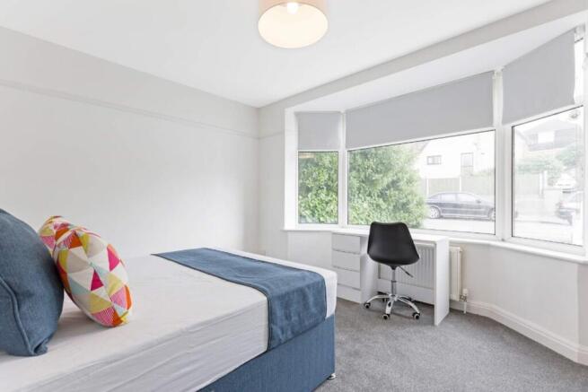 A bright and inviting double bedroom with styli...