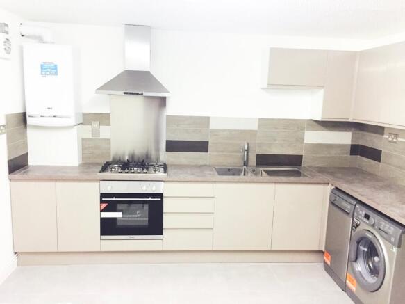 Modern and spacious kitchen featuring sleek cab...