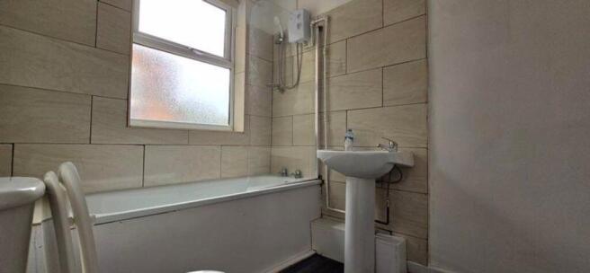 A spacious and bright bathroom featuring a comf...