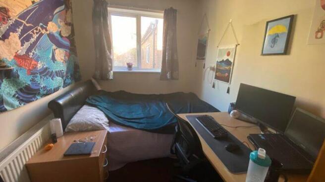 A cozy and bright double bedroom with a comfort...