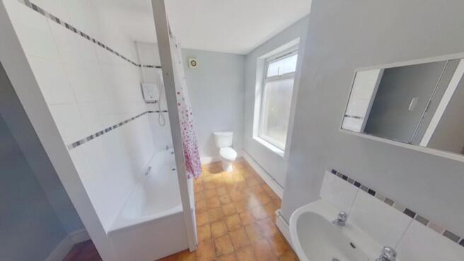 A spacious and bright bathroom featuring a bath...