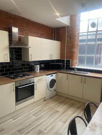 A spacious and modern kitchen featuring sleek c...