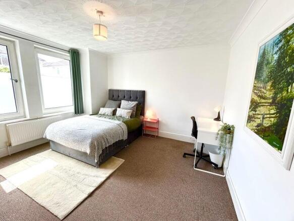 Bright and spacious master bedroom featuring a ...