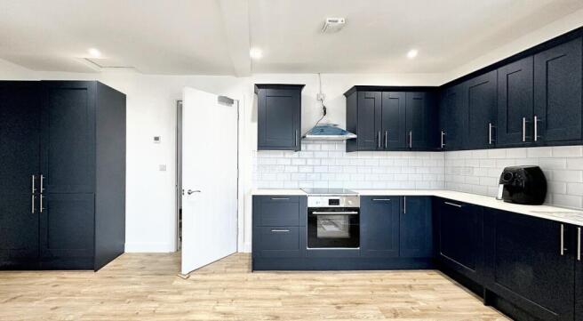 Modern kitchen with sleek navy cabinetry, ample...