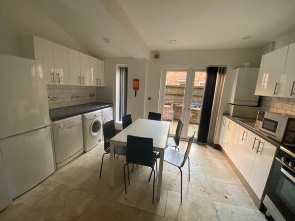 A spacious and modern kitchen equipped with ess...