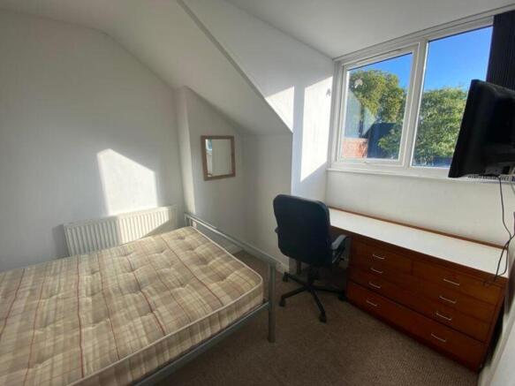 A bright and inviting double bedroom with a com...