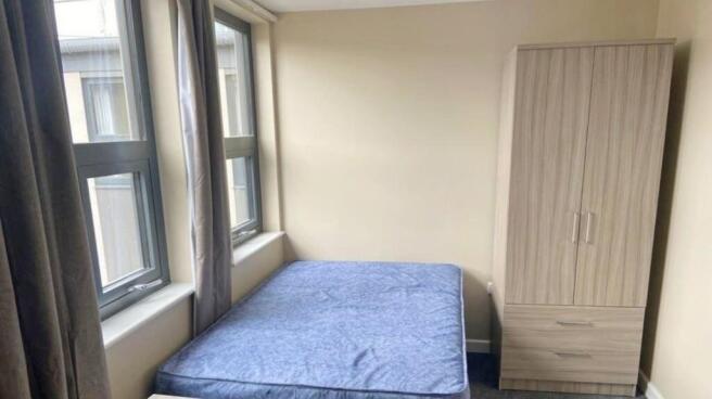 A bright and inviting double bedroom with large...