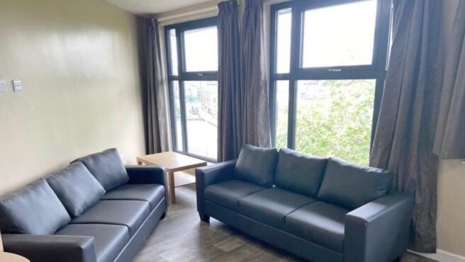 A bright and spacious living room, featuring la...