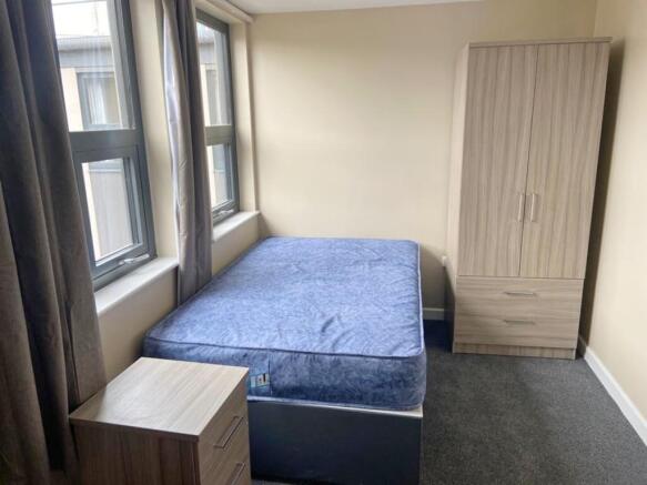 A cozy double bedroom featuring large windows t...