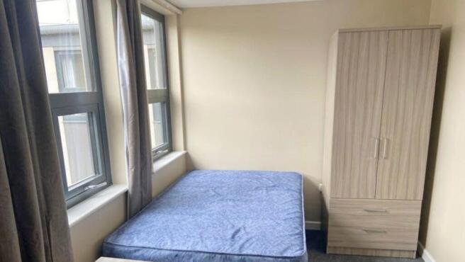 A bright and inviting double bedroom with large...