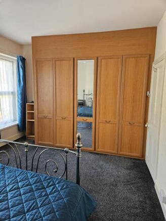 A cozy double bedroom featuring ample storage w...