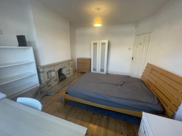 A spacious double bedroom featuring a comfortab...