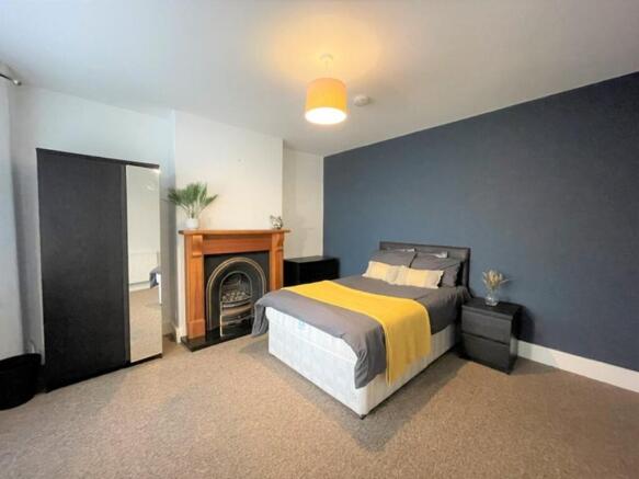 This spacious double bedroom features a cozy am...
