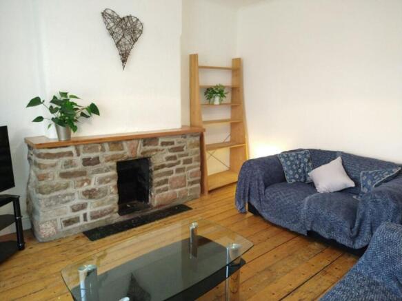 A cozy living room featuring a charming stone f...
