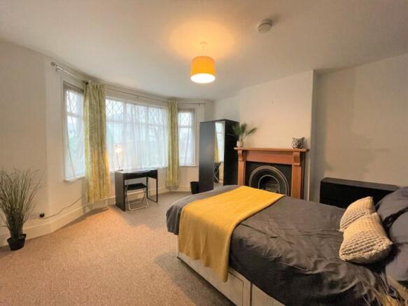 Spacious master bedroom featuring abundant natu...