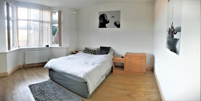 Spacious double bedroom featuring large windows...