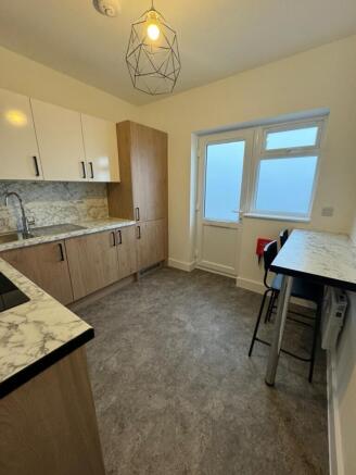 Bright and modern kitchen featuring stylish cab...