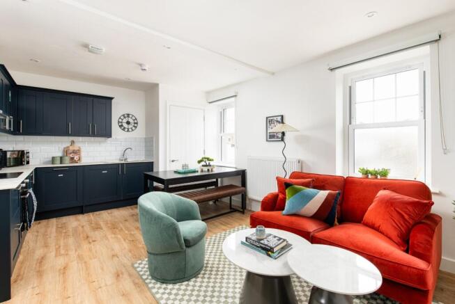 This stylish living room features a cozy red so...