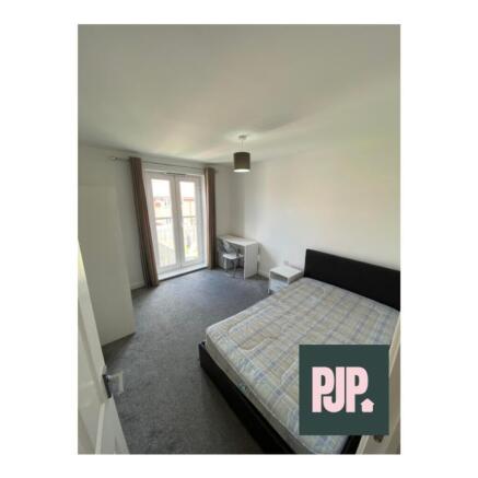 Spacious double bedroom featuring large windows...