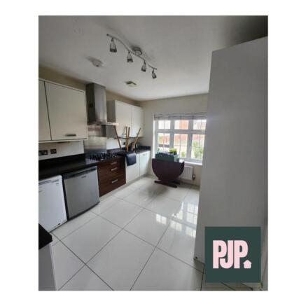 Spacious and modern kitchen featuring sleek cab...