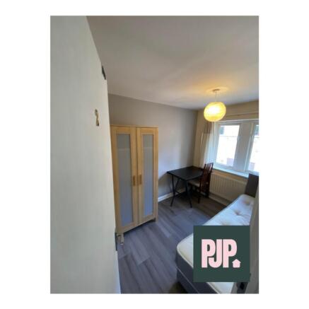 A stylish double bedroom featuring natural ligh...