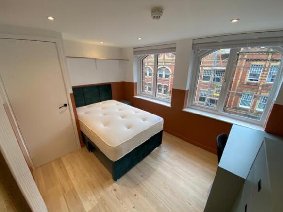 Spacious double bedroom featuring large windows...