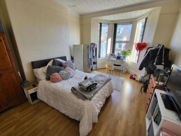 A cozy double bedroom featuring a large bay win...