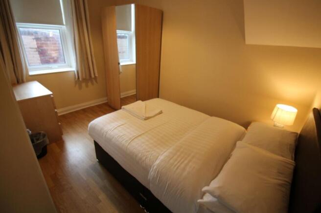 This inviting double bedroom features a spaciou...
