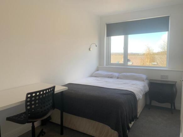 This inviting double bedroom features a comfort...