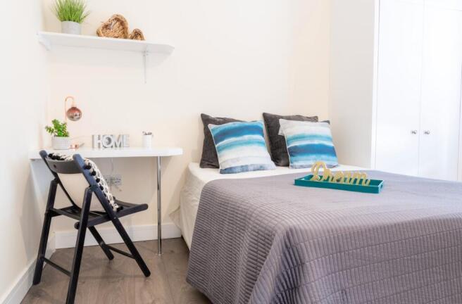 This inviting double bedroom features a comfort...