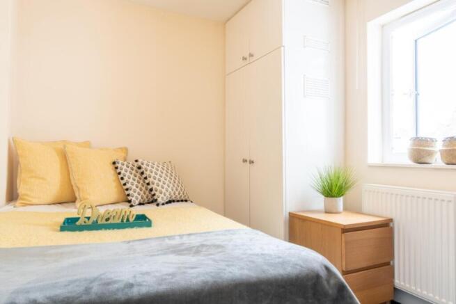 A cozy double bedroom featuring a comfortable b...