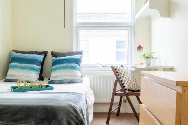 This inviting double bedroom features a cozy at...